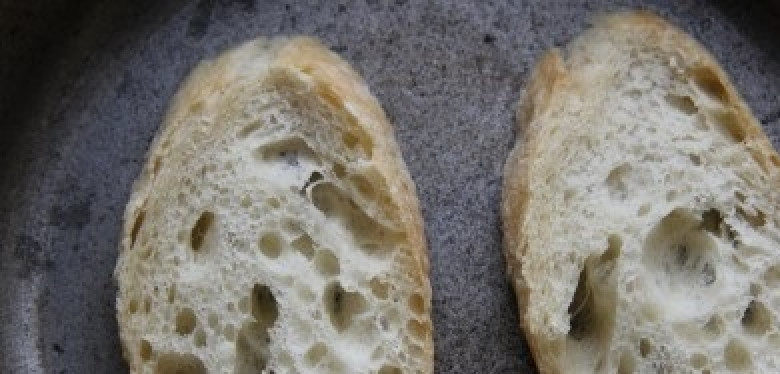 1. Этап. Бутерброды со шпротами, яйцом и огурцом: Порезанный багет подсушиваем с одной стороны на сковороде. Затем натираем чесноком.