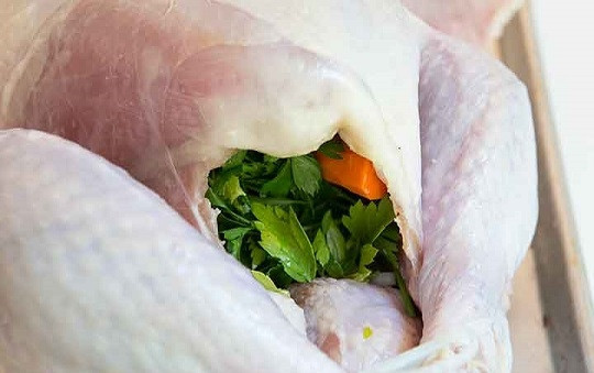 1. Этап. Индейка с клюквенным соусом: 1. Первым делом нужно заняться птицей. Вымойте ее как следует под проточной водой и тщательно обсушите. Очистите луковицу и морковь, нарежьте пополам. Выложите внутрь. Вымойте пучок петрушки, пару веточек розмарина и поместите к овощам. Аккуратно завяжите ножки, чтобы индейка с клюквенным соусом в домашних условиях на столе смотрелась более аппетитно.