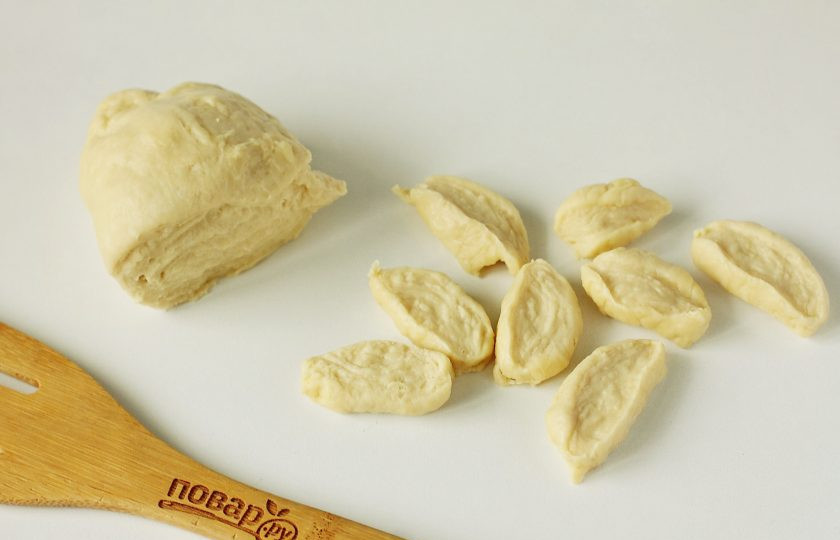 1. Этап. Галушки на сметане: Дайте тесту полежать примерно 20 минут, а затем отрежьте от него кусок и раскатайте колбаской. Нарежьте колбаску на небольшие кусочки.