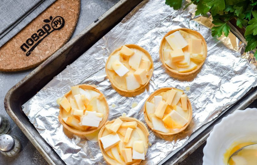 1. Этап. Тарталетки с грушей и сыром: В каждую тарталетку влейте по 2-3 ложки смеси сливок и желтка.