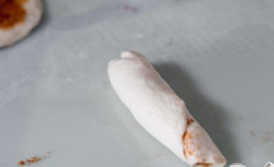 1. Этап. Булочки с корицей в глазури: 3. Свернуть печенье в рулет и защипнуть края, затем разрезать каждое пополам.