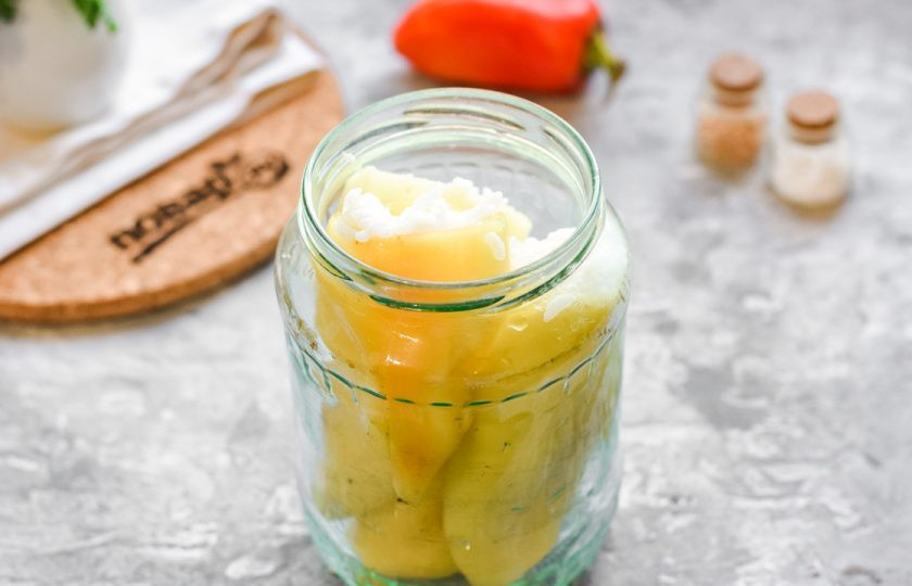 1. Этап. Перец фаршированный рисом на зиму: Переложите перцы в стерильную банку. Отдельно вскипятите томат с солью и сахаром, добавьте уксус.