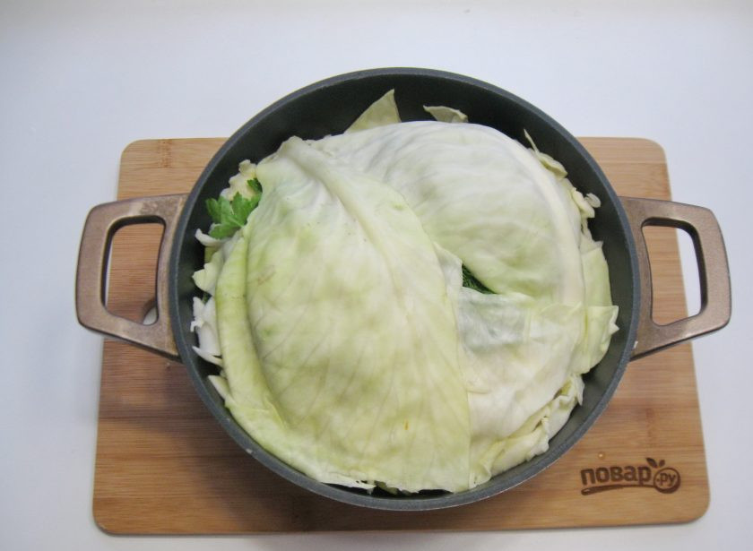 1. Этап. Басма в казане: Накройте мясо с овощами листами капусты. Накройте казан крышкой и поставьте груз. Это может быть банка с водой или просто что-то тяжелое. Благодаря этой процедуре овощи выделят много сока.