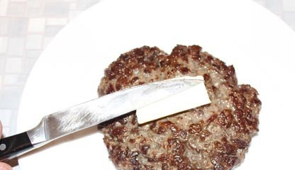 1. Этап. Бифштекс из фарша в духовке: Теперь пришла пора сформировать итоговое блюдо. На плоское большое блюдо выкладываем горячий (только что из духовки) бифштекс, на него кладем небольшой кусочек сливочного масла, и….