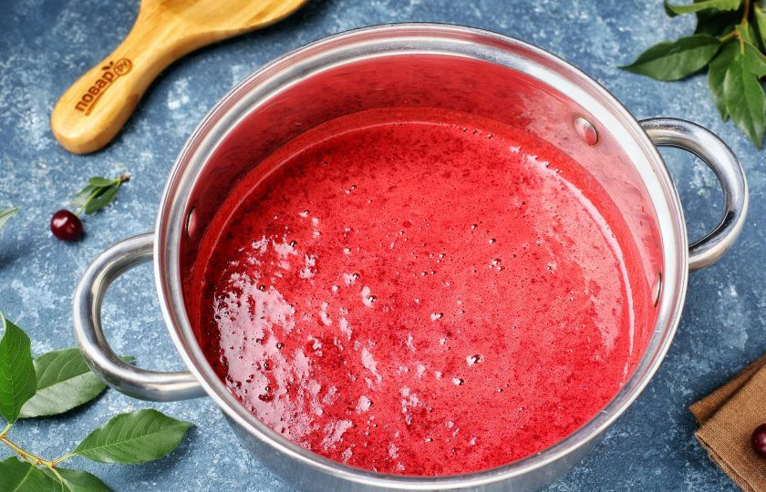 1. Этап. Джем из вишни с крахмалом: Переложите измельчённую вишню в кастрюлю, добавьте сахар и на небольшом огне, помешивая, дайте сахару раствориться.