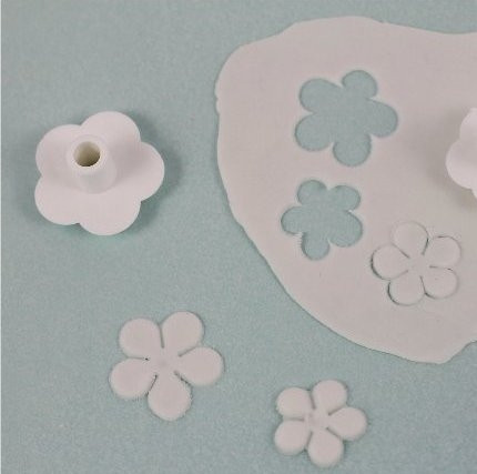1. Этап. Сахарные цветы: Используя вырубки в форме цветка, вырежьте из белой мастики несколько цветов.