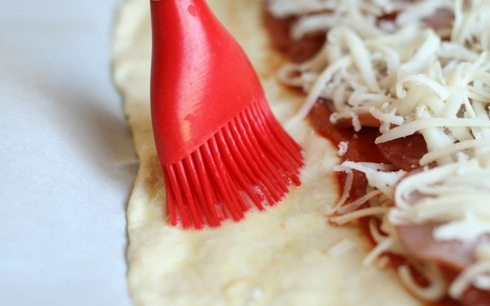 1. Этап. Закрытая пицца Стромболи: 5. Взбейте яйцо в небольшой мисочке и промажьте им край теста.