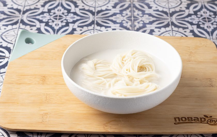 1. Этап. Холодная лапша с соевым молоком Конггуксу: Выложите в миску лапшу, влейте соевое молоко. Сверху выложите овощи и добавьте жареный кунжут. Также можно добавить пару кубиков льда.