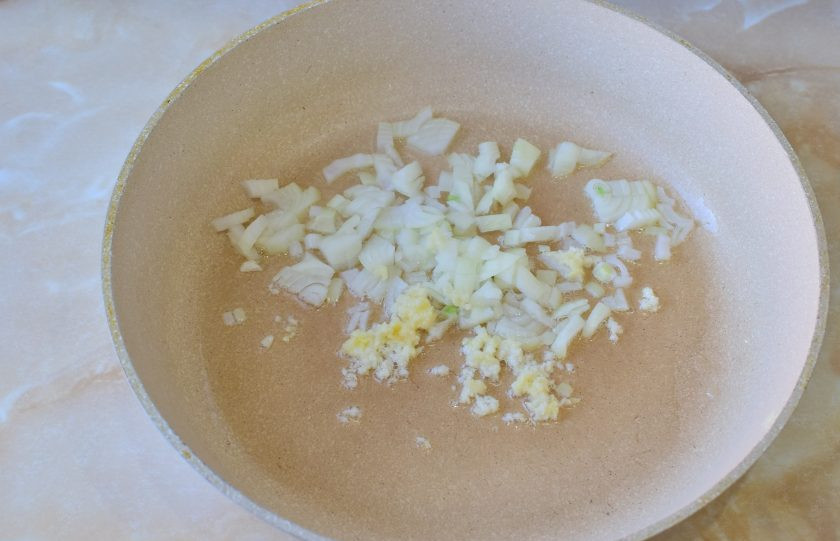 1. Этап. Тепаньяки с курицей: В горячую сковороду налейте немного растительного масла. Выложите в неё измельченные лук, чеснок и имбирь. Обжарьте 1-2 минуты.