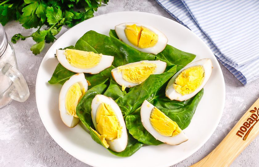 1. Этап. Салат с копчеными яйцами: Выложите сметану на листья. Нарежьте копченые яйца на четвертинки и выложите на свежую зелень.