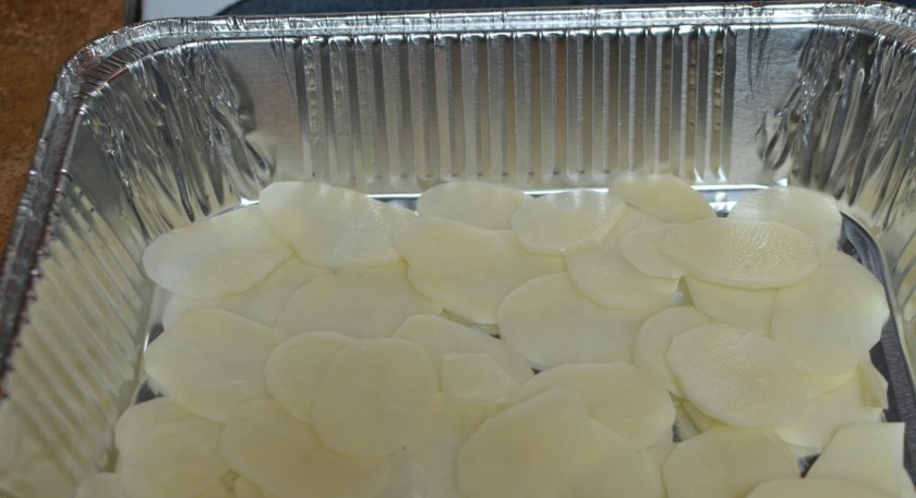 1. Этап. Картофельная запеканка с мясом и грибами: 2. На дно смазанной маслом формы выкладываем картошку, порезанную тонкими ломтиками. Специями посыпаем на свое усмотрение. Сверху выкладываем курицу и нарезанные пластинками грибы.