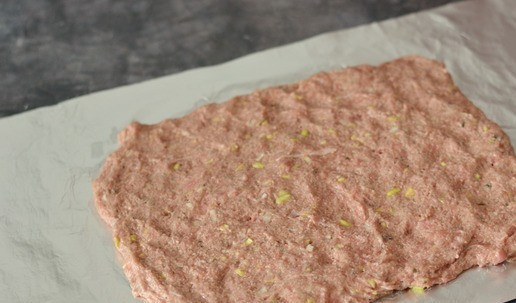 1. Этап. Рулет из утиного фарша с яйцом: Расстелите на столе лист фольги или пергамента. Распределите на нём фарш, сформировав прямоугольник. Толщина слоя фарша должна быть примерно 1,5-2 см.