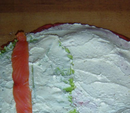 1. Этап. Блины закусочные: На край блина выкладываем помытый и подсушенный лист салата и смазываем его кремом. Сверху выкладываем тонкие кусочки красной рыбы.