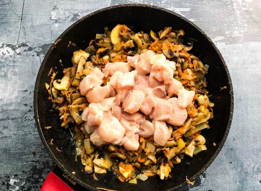 1. Этап. Перловка с курицей и грибами: Куриное филе нарежьте небольшими кусочками, добавьте его к овощам с грибами и обжарьте в течение 5 минут.