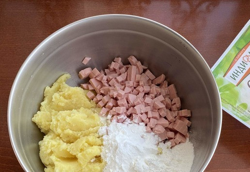 1. Этап. Картофельные пончики с моцареллой: Из отварного картофеля приготовьте пюре. Добавьте кукурузный крахмал, соль и чесночный порошок. Молочные сосиски от ТМ 