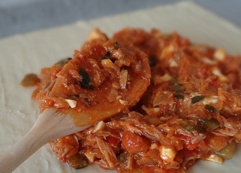 1. Этап. Слоеный пирог с тунцом: Заранее размороженное тесто делим на две части. Выкладываем одну часть теста на противень, застеленный пергаментом, и выкладываем на него начинку.