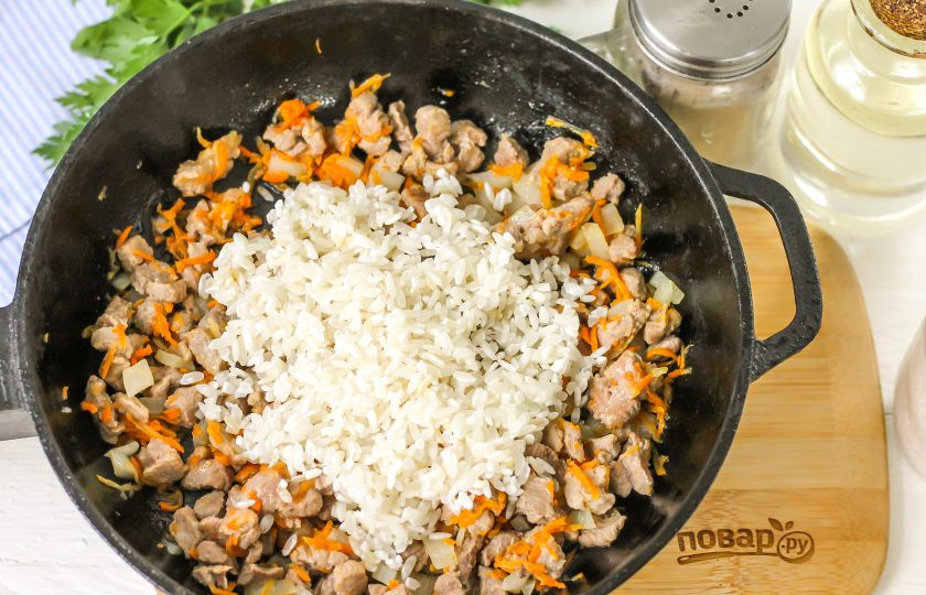 1. Этап. Долма из перцев: Всыпьте промытый рис, обжарьте около 1 минуты.