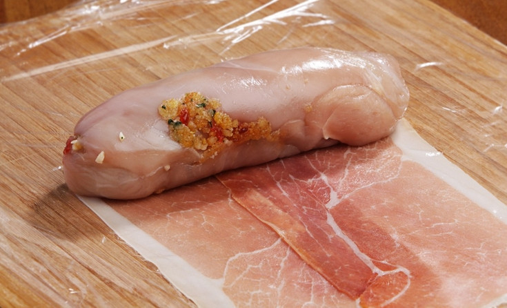 1. Этап. Куриный рулет в пищевой пленке: Заворачиваем рулет в ломтики прошутто.