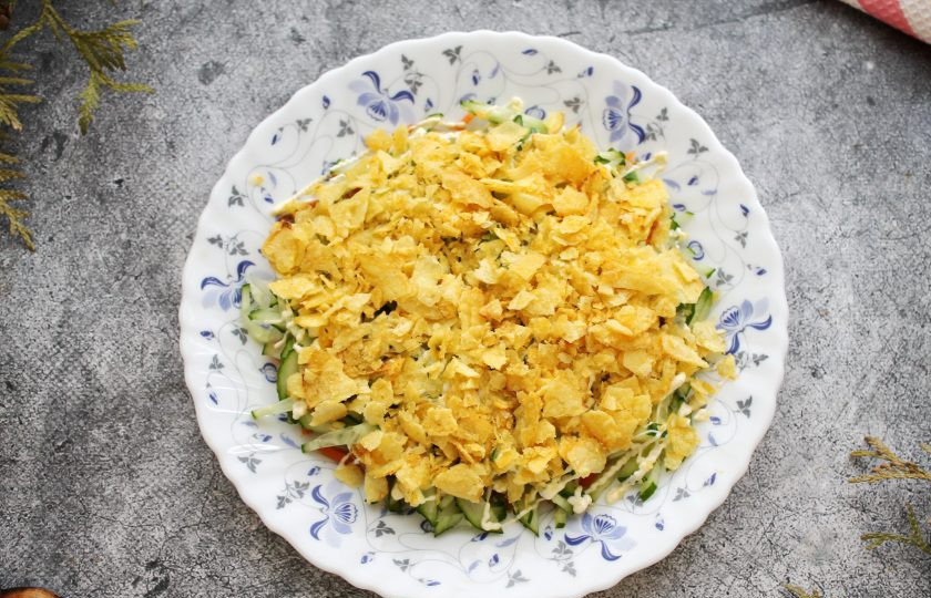 1. Этап. Салат Орхидея с чипсами и ветчиной: Отберите самые красивые и ровные чипсы, по три штуки на цветок, остальные измельчите и посыпьте поверх огуречного слоя.