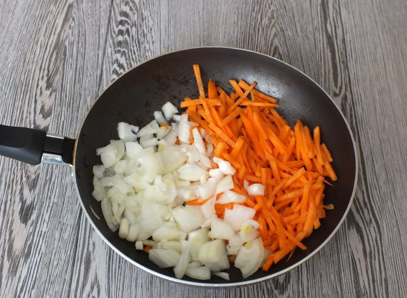 1. Этап. Плов в рукаве: В сковороду, где обжаривалось мясо, налейте растительное масло. Переложите лук и морковь. Обжарьте до полуготовности.