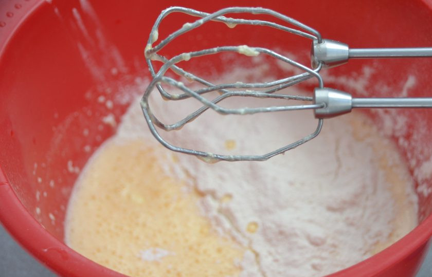1. Этап. Итальянское яблочное печенье: Всыпьте к муке разрыхлитель, затем частями введите муку в тесто, продолжая взбивать.