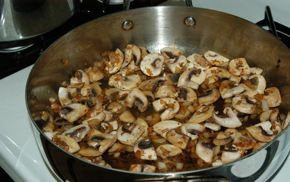 1. Этап. Бефстроганов с грибами и луком: Добавьте грибочки так, чтобы они легли на лук плотно и равномерно. Добавьте щепотку соли. Обжаривайте в течении 10 минут, до того, как вся жидкость испарится.