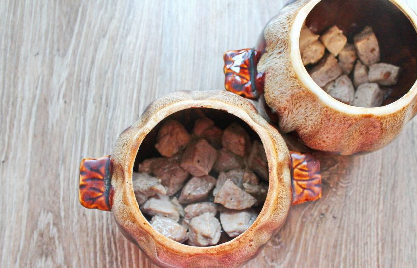 1. Этап. Жаркое по-киевски: Возьмите два горшочка для запекания и поровну разложите в них обжаренное мясо.