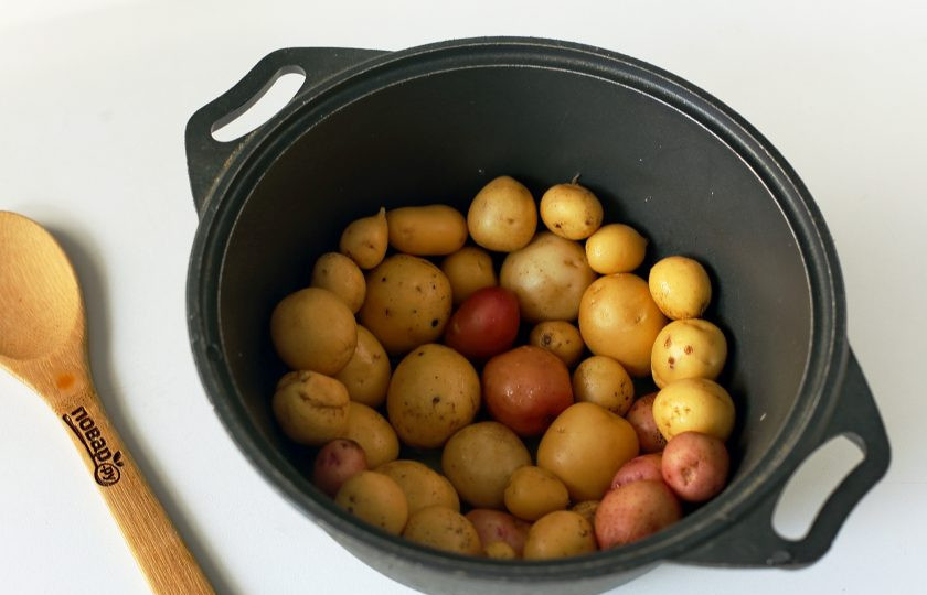 1. Этап. Азербайджанский плов с тыквой: В казане растопите пару ложек масла, выложите всё дно и немного боковые стенки казана нарезанным на кружки картофелем. Добавьте поверх картофеля ещё 1-2 ложки масла и посыпьте щепоткой соли. Так как у меня был молодой картофель небольшого размера, то я его не стала нарезать. Просто тщательно помыла щеточкой сверху и выложила им дно и стенки казана.