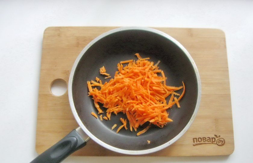 1. Этап. Диетический минтай в фольге в духовке: Морковь очистите, помойте и натрите на терке. Выложите в сковороду.