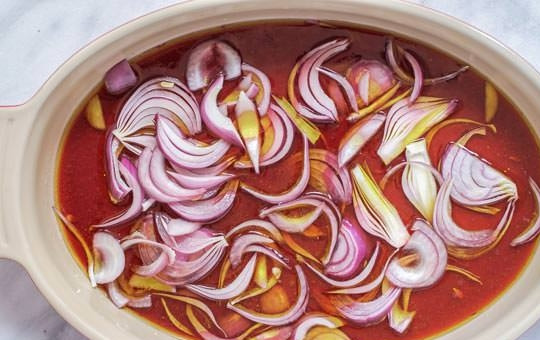 1. Этап. Быстрый рецепт шашлыка: 2. В другой миске соедините красное вино, сок двух лимонов, оливковое масло, нарежьте полукольцами 1 красный лук.