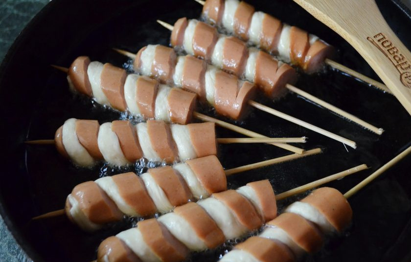 1. Этап. Хот-дог Торнадо: Разогрейте растительное масло в сковороде. В горячее масло положите хот-доги, они должны быть покрыты маслом минимум на половину, а лучше — целиком.