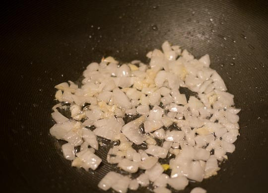 1. Этап. Рис с курицей на сковороде: 4. В сковороде на масле обжарьте измельченный чеснок и лук, обжарьте до полупрозрачности.