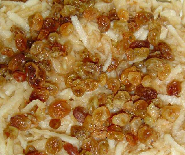 1. Этап. Пирожки с яблоками на сковороде: Тем временем приготовим начинку. Замачиваем изюм в горячей воду и оставляем на 10 минут. Яблоки очищаем и трем на крупной терке, поливаем их соком половины лимона и добавляем изюм, перемешиваем все.