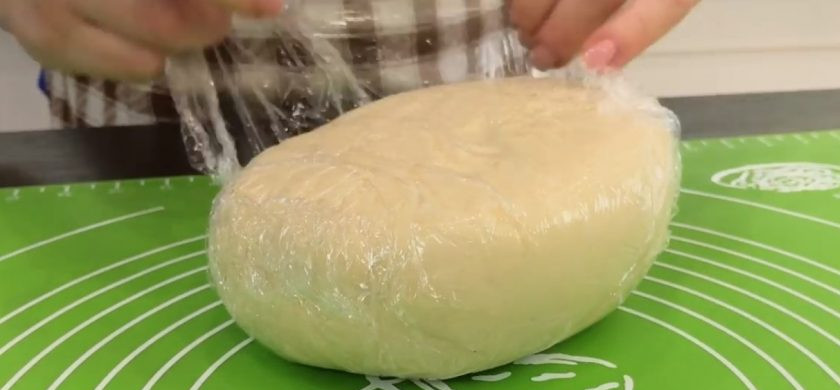 1. Этап. Вареники с мясом на заварном тесте: 2. Переложите получившееся тесто на стол, замесите его, после этого вымесите тесто в течение 5-7 минут. Сформируйте из теста шар, заверните его в пищевую пленку и отправьте в холодильник на 30-60 минут.