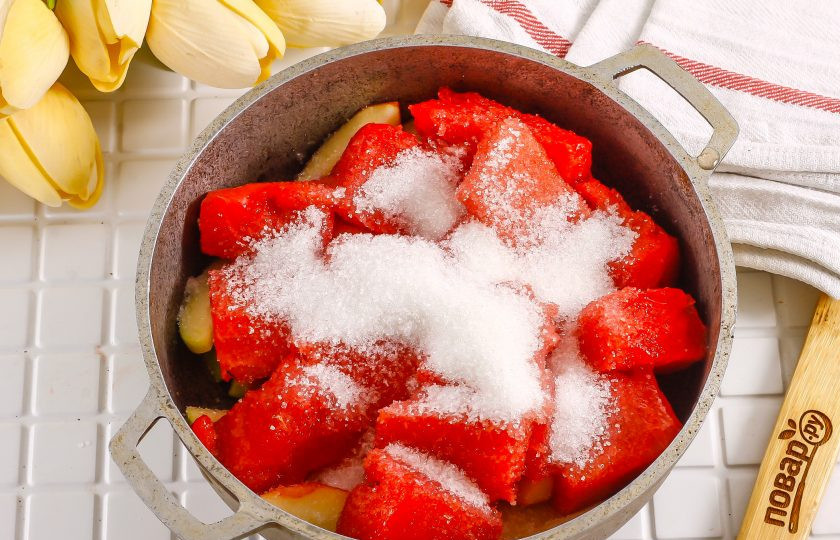 1. Этап. Варенье из арбуза и яблок: С арбуза срежьте красную мякоть, удалите из нее все семена и нарежьте крупными кусочками в емкость с яблоками. Всыпьте сахарный песок.