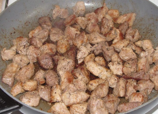1. Этап. Свинина в горшочке с грибами: 1. Вымойте мясо и нарежьте небольшими кубиками. Разогрейте сковороду с растительным маслом и обжарьте мясо, посолите и поперчите.