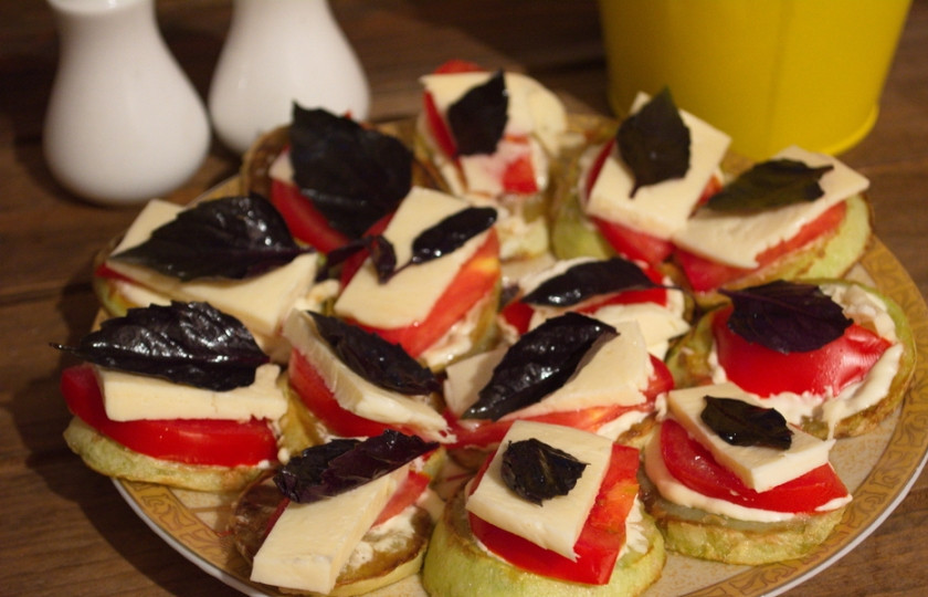 1. Этап. Жареные кабачки с помидорами и сыром: Кавказский сыр нарезать на пластинки, тоненько. По кусочку сыра уложите поверх каждой помидорной дольки.