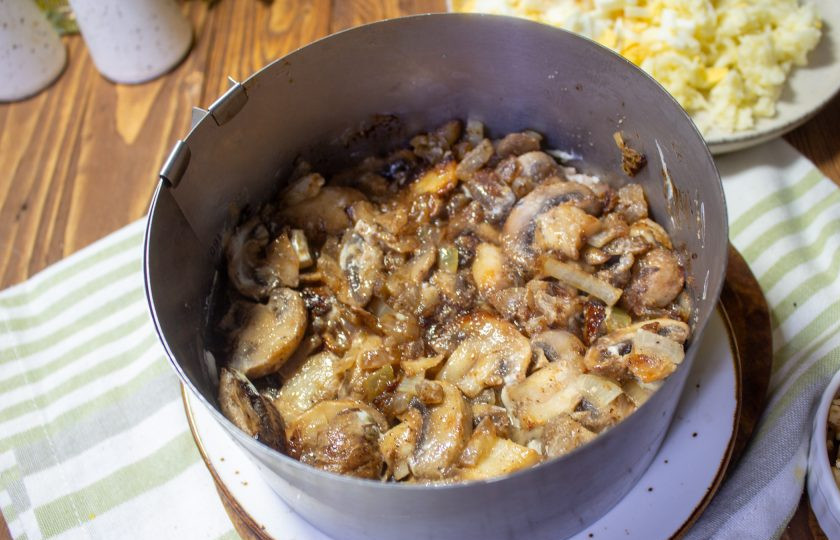 1. Этап. Салат с курицей, грибами и грецким орехом: Следующий слой — обжаренные грибы с луком. Этот слой смазывать майонезом не обязательно.