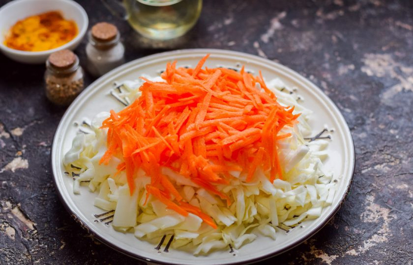 1. Этап. Капуста с аджикой: Морковь очистите и сполосните, натрите на терке, добавьте к капусте.