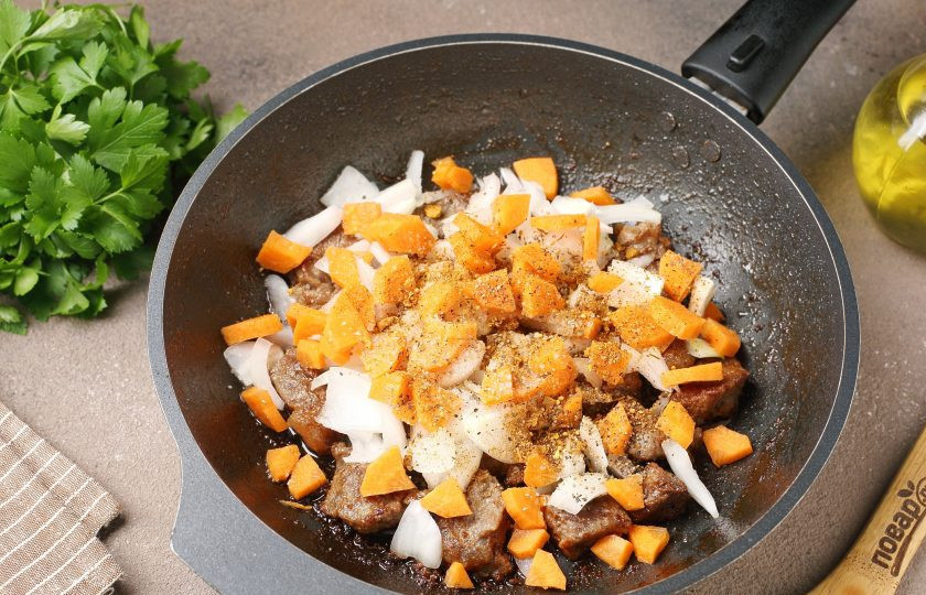 1. Этап. Каша гречневая с говядиной: Добавьте нарезанные произвольно лук и морковь. Посолите и добавьте специи по вкусу.