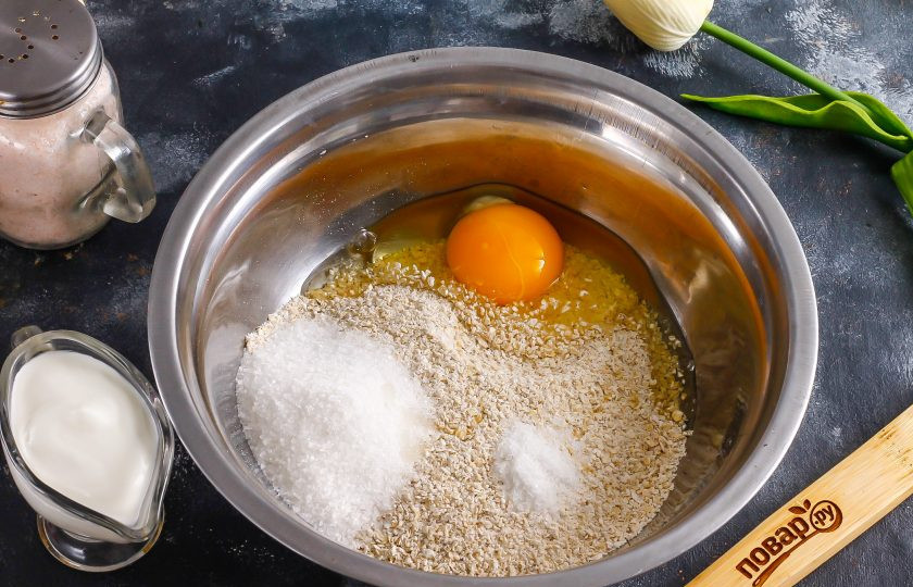 1. Этап. Полезные ватрушки с творогом: Пересыпьте их в глубокую емкость, вбейте туда же куриное яйцо, всыпьте сахарный песок и соль.