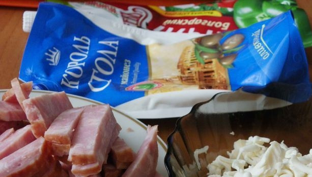 1. Этап. Пицца на хлебе: Подготовьте начинку для вашей пиццы. Для этого плавленый сыр натрите на терке. Чтобы это было сделать легко, подморозьте его в морозильной камере. Тогда он будет очень просто натираться. Ветчину или колбаску нарежьте тоненькой соломкой. Для соуса соедините майонез и кетчуп.