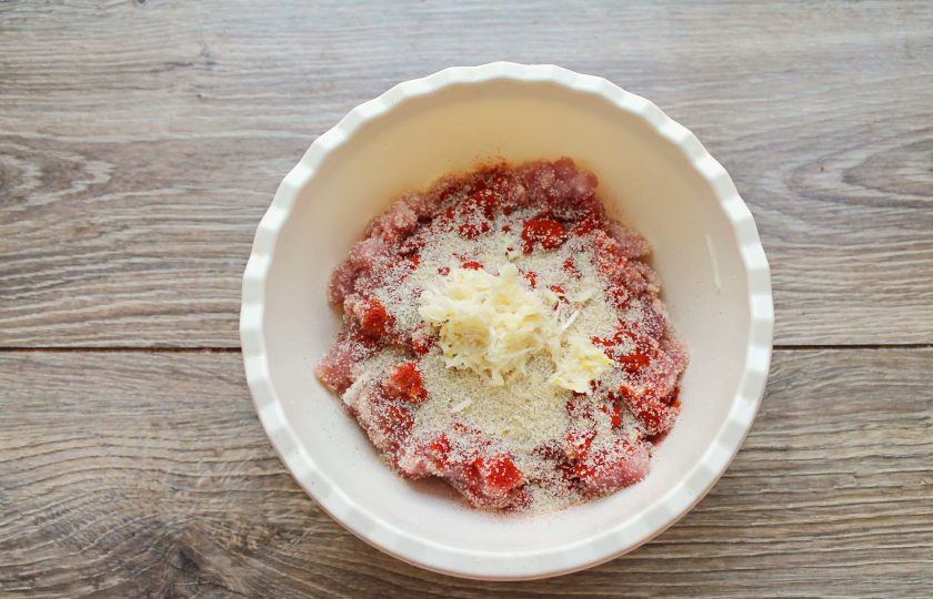 1. Этап. Мясное желе: Всыпьте в мясо сухой желатин и мелко нарезаный чеснок.