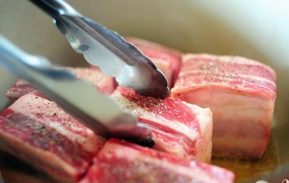 1. Этап. Говяжьи ребрышки в томатном соусе: 1. Разогреть духовку до 135 градусов. Измельчить чеснок. Нарезать луковицу кубиками. Натереть сыр, нарубить петрушку. Нагреть оливковое масло в большой кастрюле на среднем огне. Посыпать ребрышки солью и перцем. Обжаривать в масле около 1 1/2 или 2 минуты с каждой стороны. Снять с огня и выложить на блюдо.