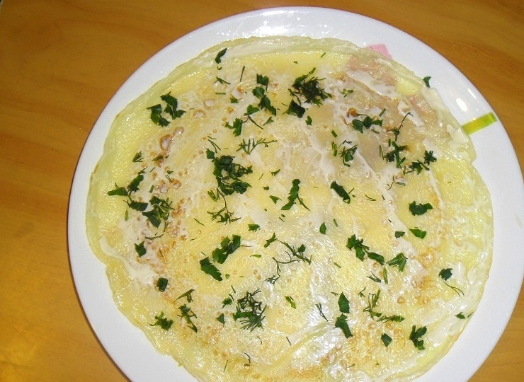 1. Этап. Блины с красной рыбой и огурцом: Возьмите верхний блин из стопочки и положите на отдельную тарелку. Смажьте его майонезом или плавленым сыром и присыпьте немного зеленью.