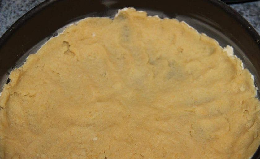 1. Этап. Рецепт сливового пирога от Юлии Высоцкой: Форму для выпечки смажьте маслом. Выложите на дно тесто, сделав бортики.