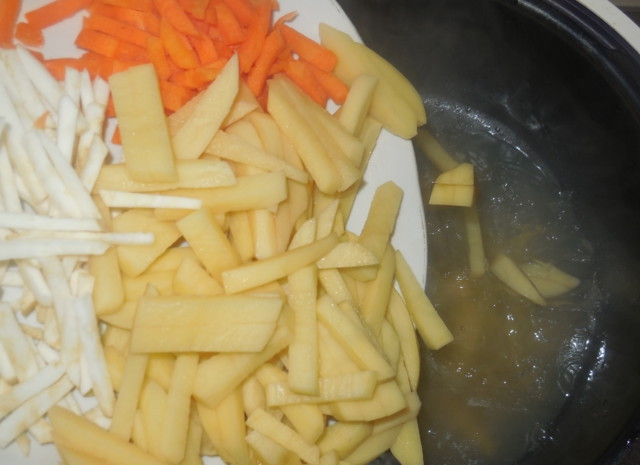 1. Этап. Уха из щучьих голов: Бульон влейте назад в чашу мультиварки. Доведите его до кипения и добавьте овощи.