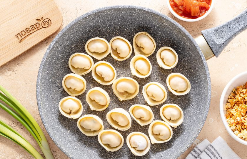 1. Этап. Пельмени с тофу и кимчи: Разогрейте сковороду на среднем огне с небольшим количеством растительного масла. Выложите туда пельмени. Обжарьте их 1-2 минуты.