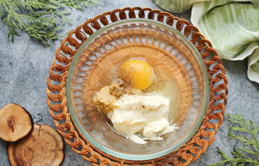 1. Этап. Майонез из сыра: В узкую небольшую миску выложите плавленый сыр, горчицу, вбейте яйцо, посолите, поперчите и влейте лимонный сок.