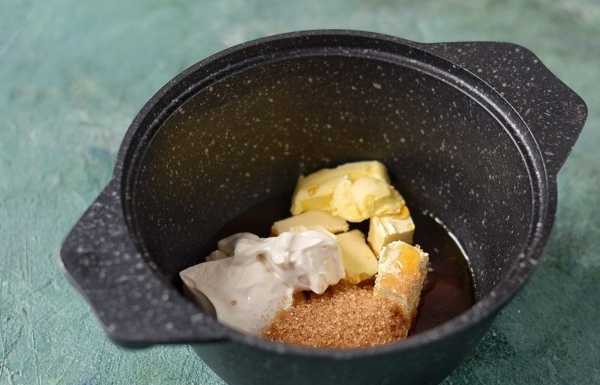 1. Этап. Постный медовик: Соедините соевую сметану, мед, коричневый сахар и маргарин. Нагрейте ингредиенты в кастрюле с толстым дном или водяной бане, пока мед и сахар не растворятся.